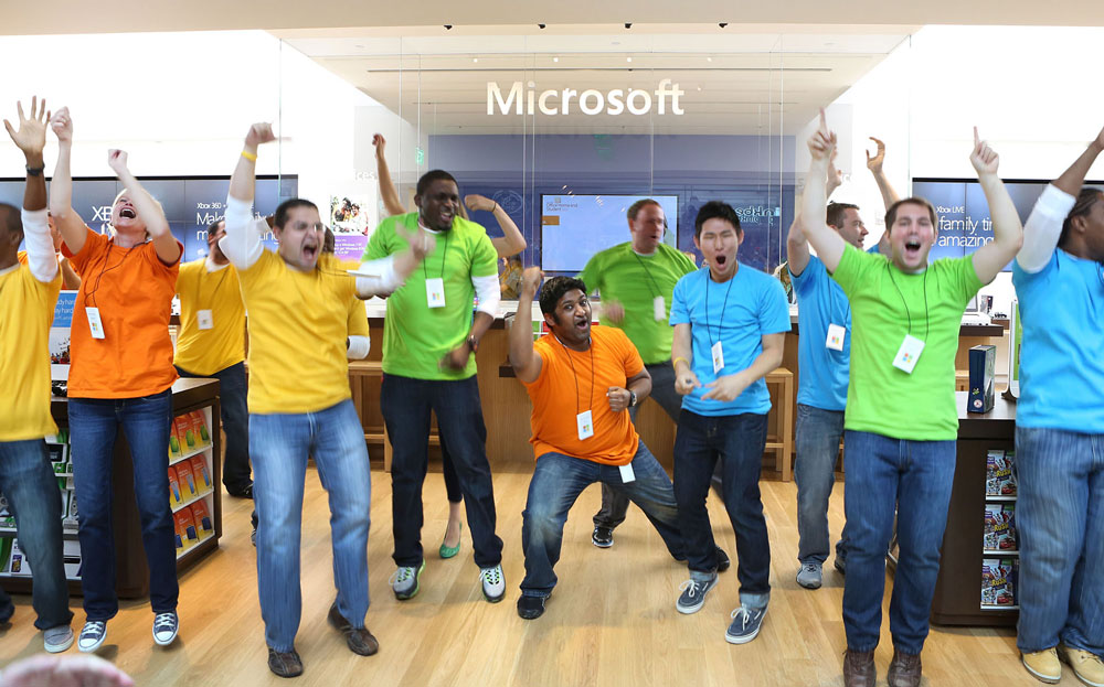 Excited store associates celebrate the grand opening of a Microsoft retail store as they prepare to welcome customers in Boston. 