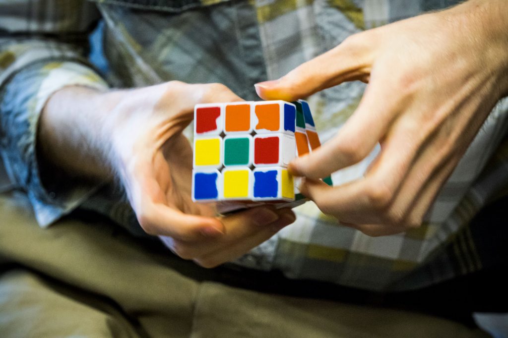 Closeup of a person playing with a multi-colored cube game