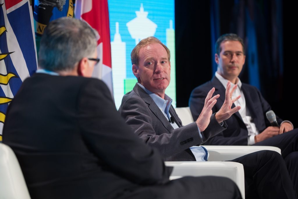 Photo of Microsoft President Brad Smith, center, Telus Chief Corporate Officer and Executive Vice President Josh Blair and Business Council of British Columbia President and Chief Executive Officer Greg D’Avignon speaking at the Emerging Cascadia Innovation Corridor Conference 