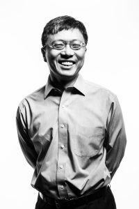 Harry Shum smiles in black-and-white portrait