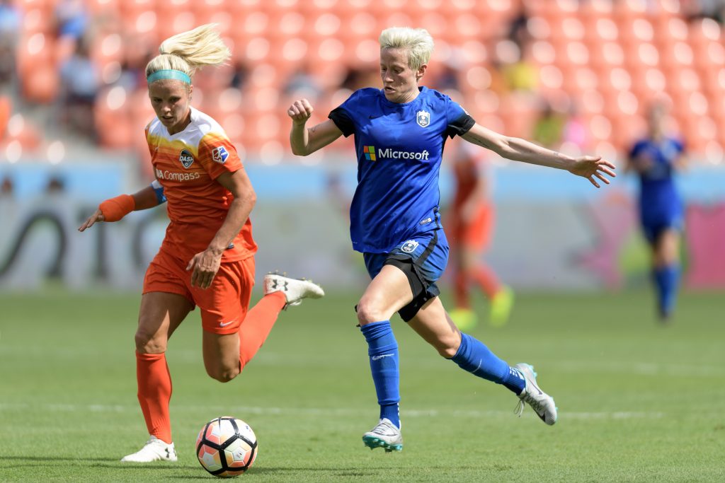 Seattle Reign midfielder/winger Megan Rapinoe and another soccer player chasing a ball