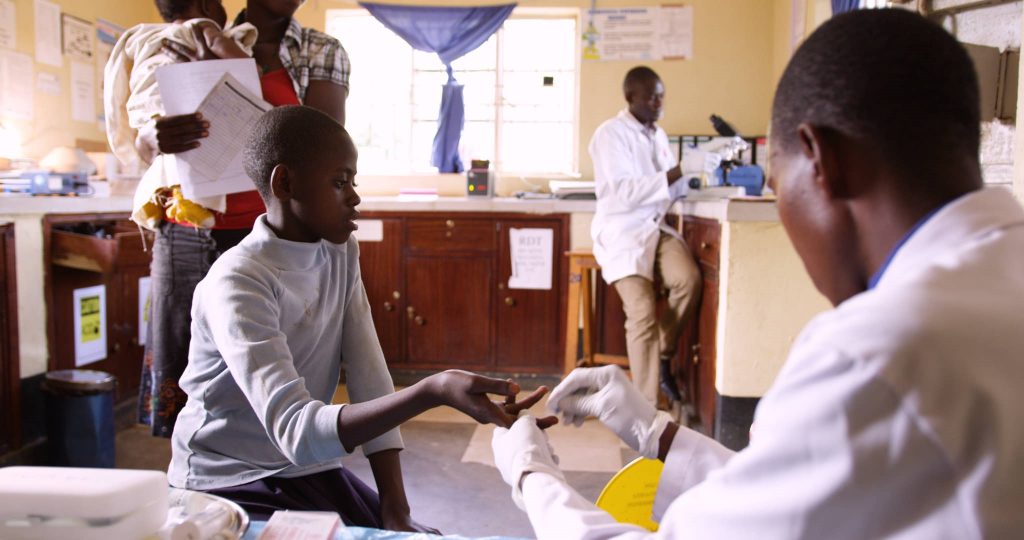 A refugee receives a medical checkup at a clinic in Uganda