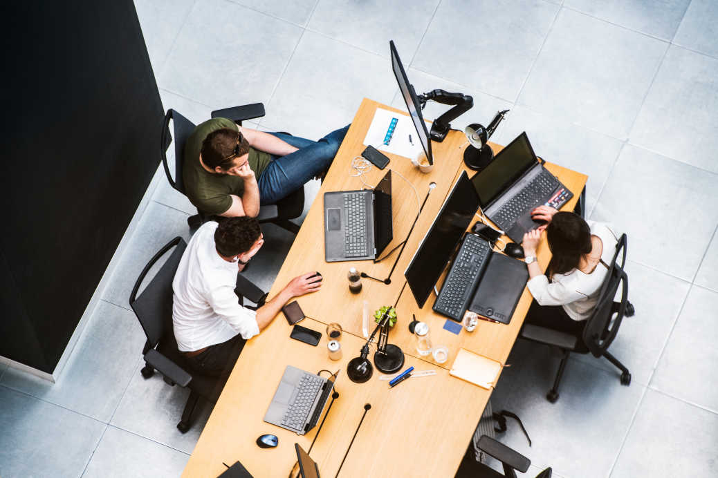 Three coworkers collaborating on computers