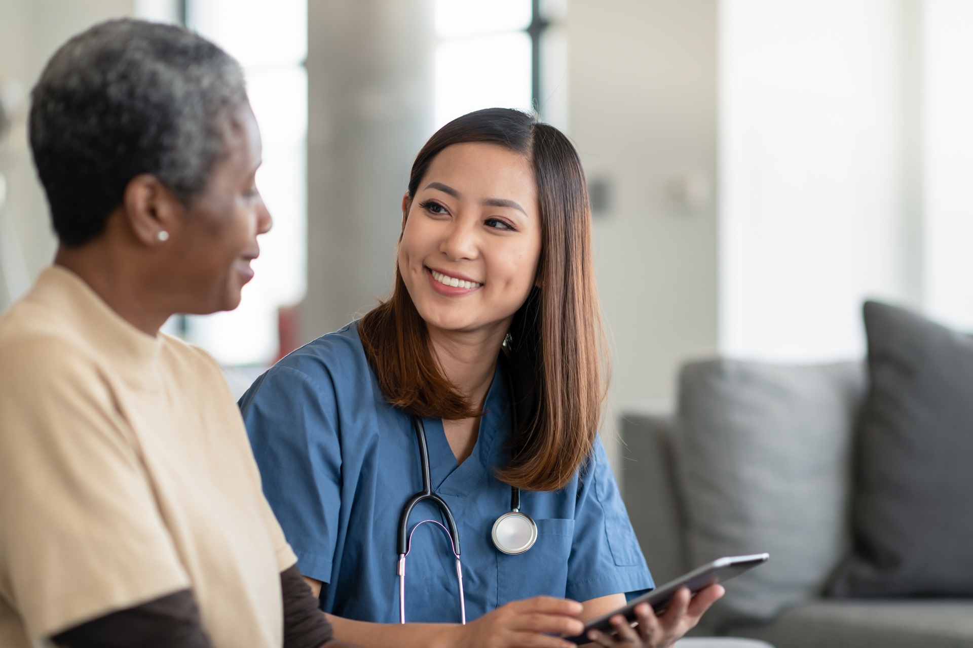 A nurse sits with their patient and consults.