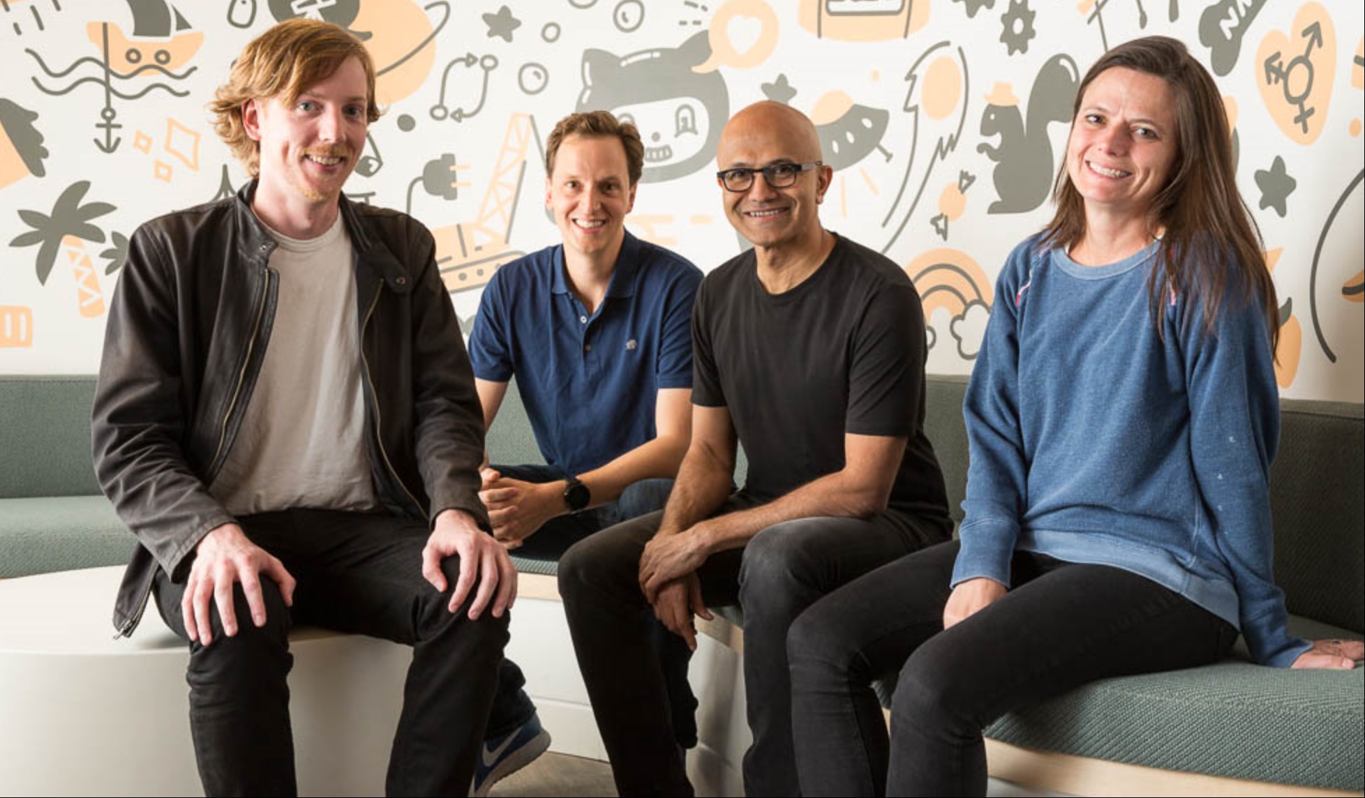 Satya Nadella sitting and posing with three people, including GitHub CEO