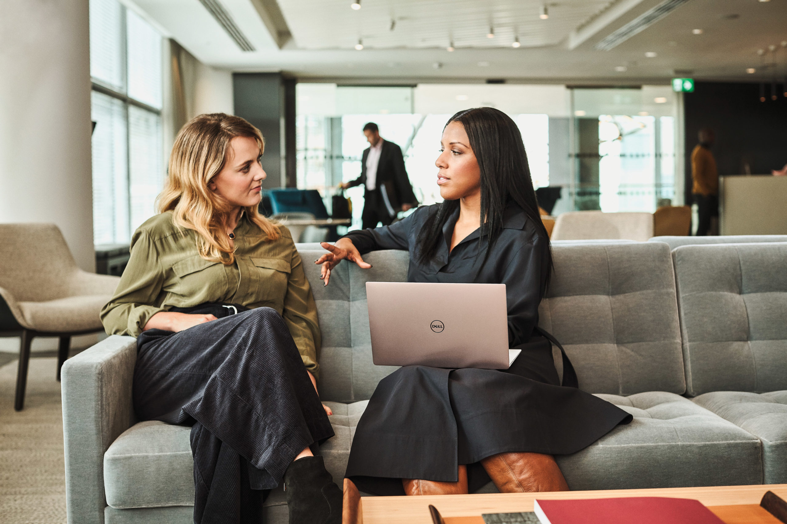 Two women conversing in an office setting