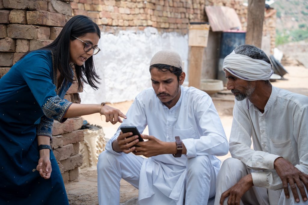 Three people looking at mobile phone