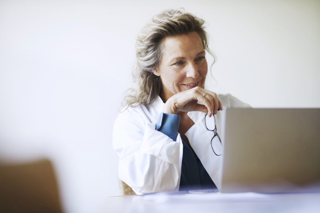 Una trabajadora médica mira un ordenador portátil