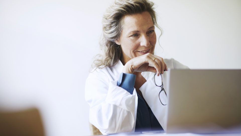 Una trabajadora médica mira un ordenador portátil