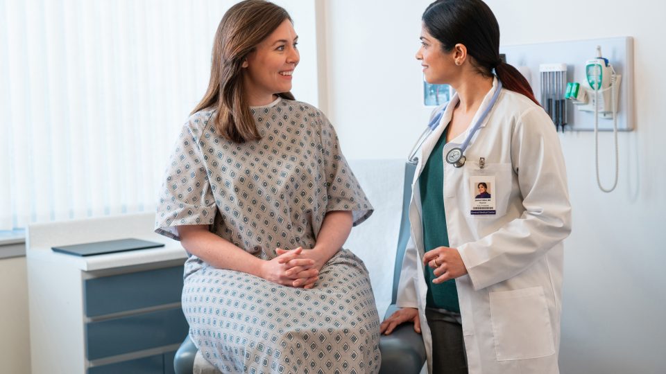 A medical clinician talking with a patient in an exam room. patient