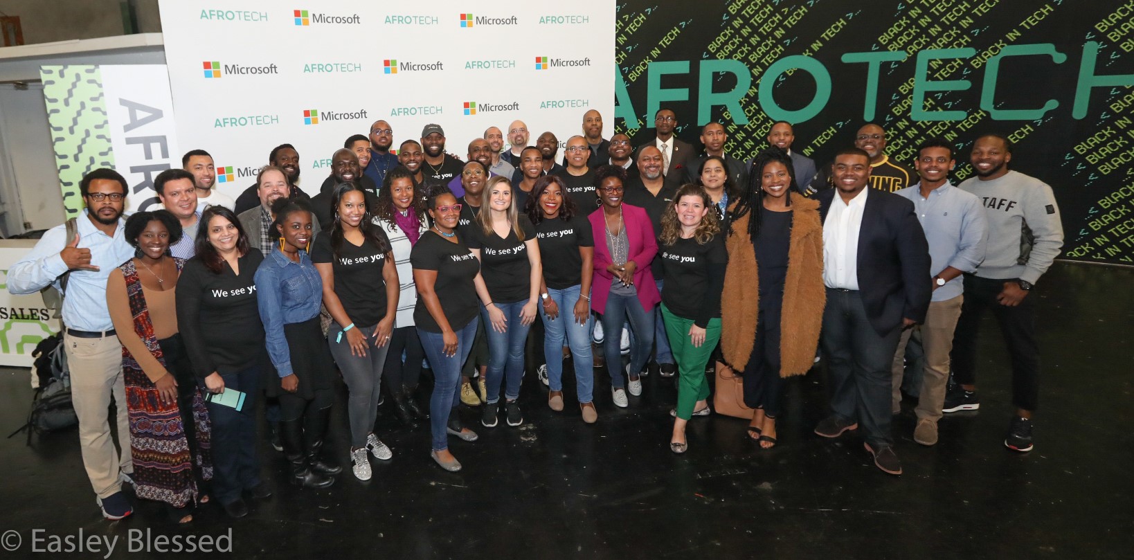 About 45 Microsoft employees pose in front of the Microsoft booth at the AfroTech conference in San Francisco