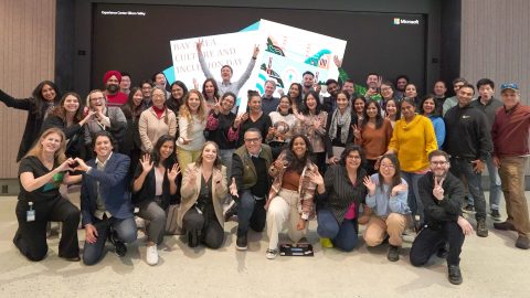 About 40 Microsoft employees smiling in front of a screen that says Bay Area Culture and Inclusion Day.