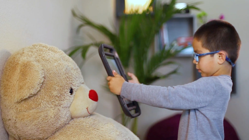 A young boy at the iTherapy clinic uses InnerVoice chat bot to describe his photo of a Teddy bear.