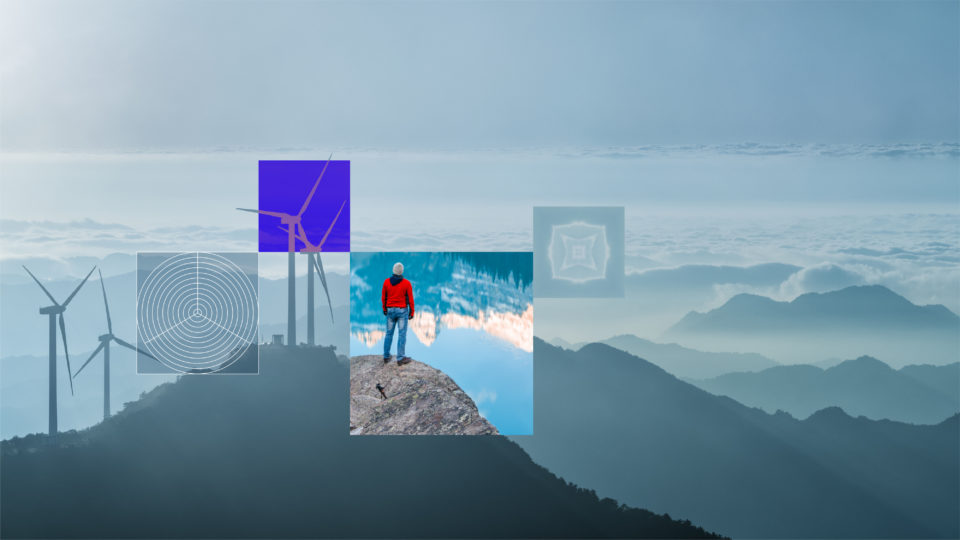 Wind turbines are shown on a mountain peak