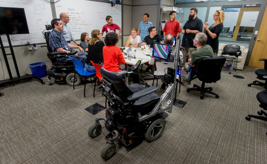 Team of researchers in a conference room at Microsoft discuss EyeGaze Wheelchair.