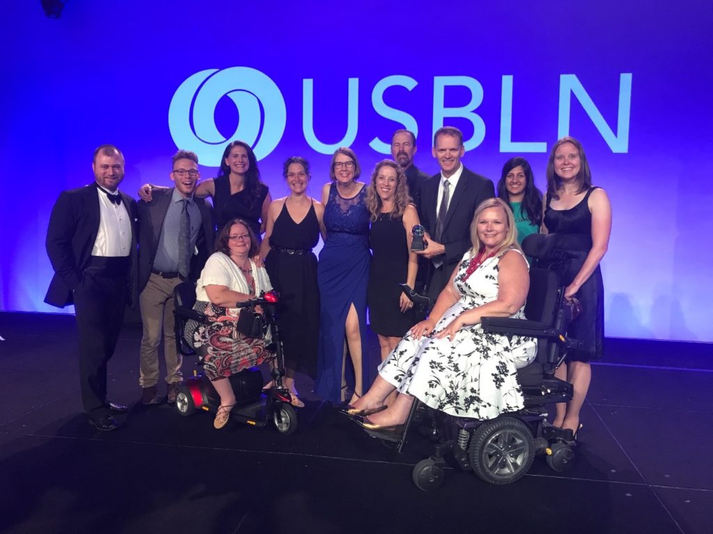 Microsoft employees gather on stage at USBLN conference to accept an award