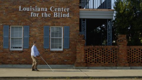 A man who is blind walking