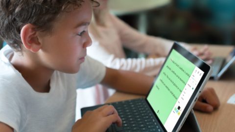 Young boy uses Learning Tools to read text on a tablet.