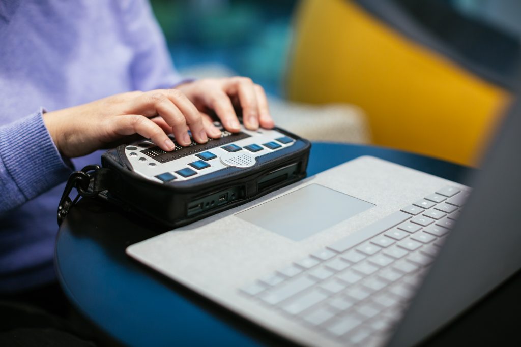 Anne Taylor, a woman who is blind, uses a braille keyboard with a Surface device.