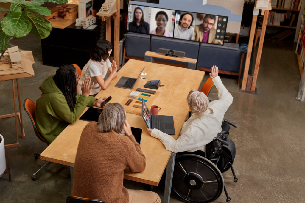 Remote attendees participating in a Microsoft Teams Room (MTR) meeting while people in the conference room are viewing attendees in Gallery View on the front of room (FoR) dual monitors​.