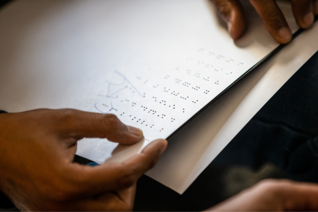 Close-up of braille sheet being read by student at a school for the blind.
