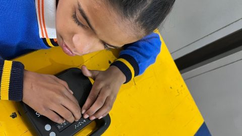 A young pupil testing a black Hexis device in a classroom setting.