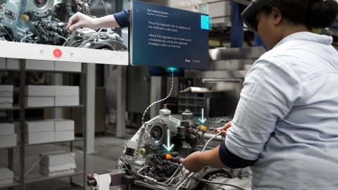 A female employee uses a HoloLens 2 with Dynamics 365 Guides hologram in front of her pointing where to attach a hose to a fuel injection system
