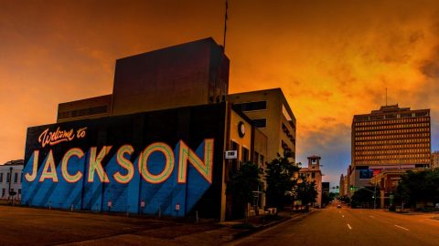 Image of a mural with the words Welcome to Jackson, against orange sky background.