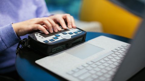a person uses an accessibility tool with a laptop