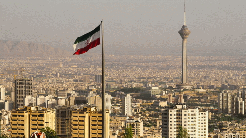 A view of Tehran, Iran, with an Iranian flag in foreground
