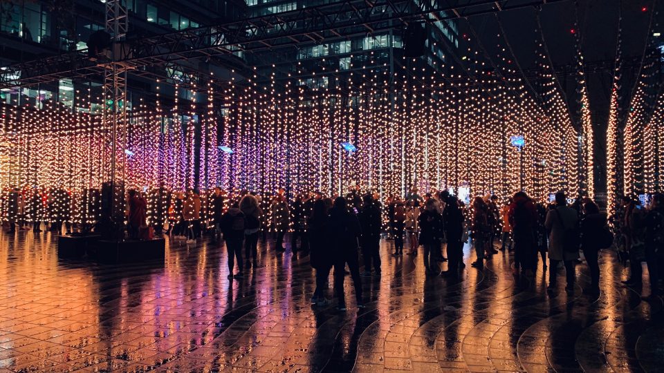 Groups of people congregating on an illuminated plaza