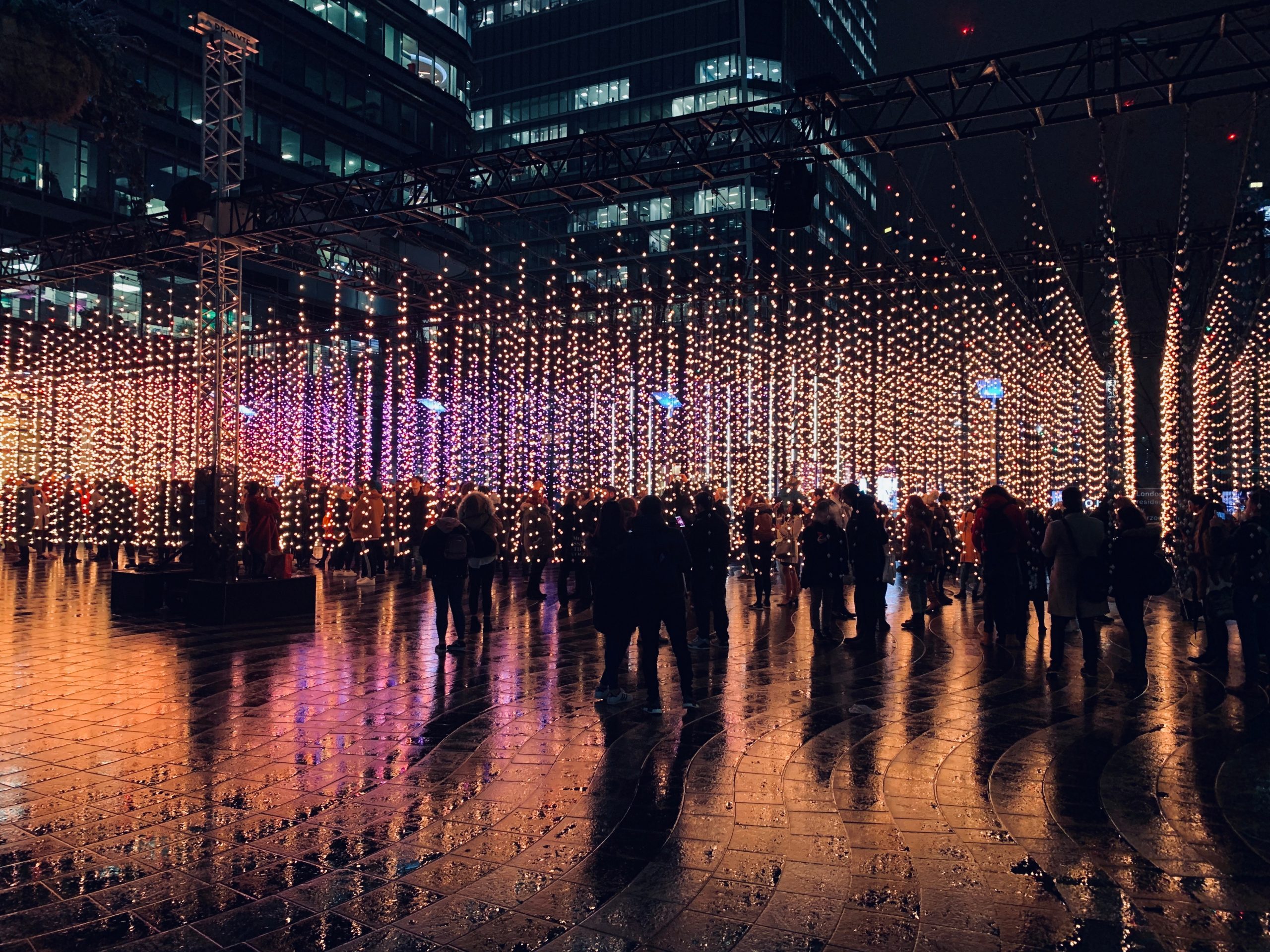 Groups of people congregating on an illuminated plaza