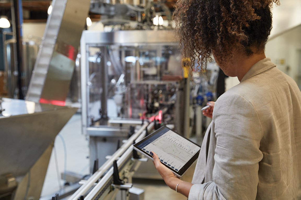 Female at work in industrial factory using Surface Pro 7